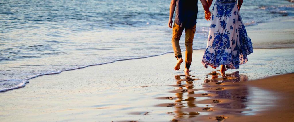 Two people walking along the beach