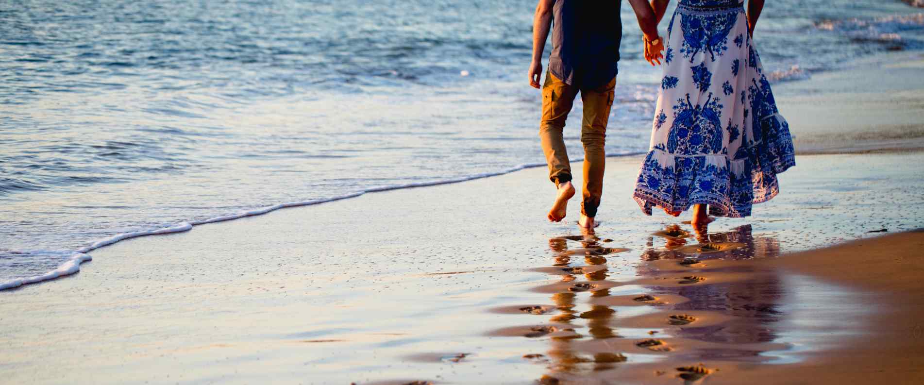 Two people walking along the beach